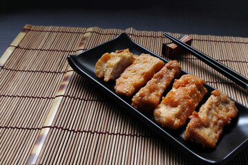 deep fried pork in the black square plate on bamboo mat in the Japanese restaurant during lunch