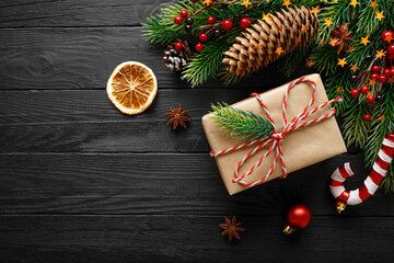 Vintage gift with christmas decorations on black wooden background