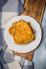 Chop pork cutlets , served with boiled potatoes and salad of pickled cucumbers on wooden board. A typical Polish dinner (kotlet schabowy).
