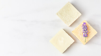 cosmetics concept panoramic banner. natural eco soap decorated with lavender flower on a marble background. space for text, top view