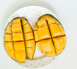 sliced ripe delicious mango on a plate on a white plate. vitamins, 