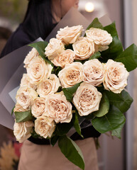 Young woman with a gift bouquet of peonies roses, mono bouquet of roses. Young woman holding fresh bouquet of roses.