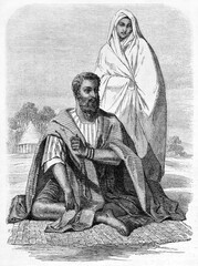 Moorish traditional dressed man crouched outdoor on a carpet and woman in the Emirate of Trarza. Ancient grey tone etching style art by De B�rard, published on Le Tour du Monde, Paris, 1861