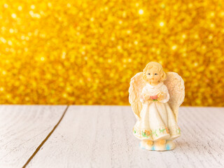 Christmas angel toy on a gold background.