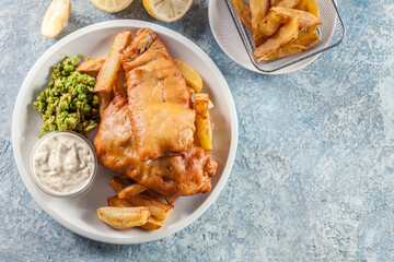Fish in beer batter and chips with green pea and tartar sauce