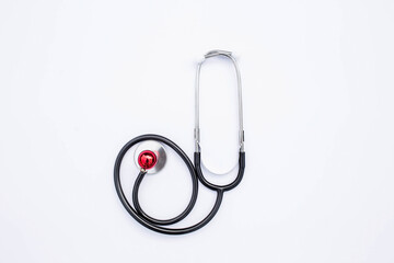 Creative medical postcard stethoscope, pills and red heart on white background. Medicine flatlay.