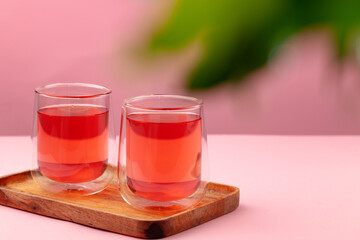 Two glass cups of black tea on beige table