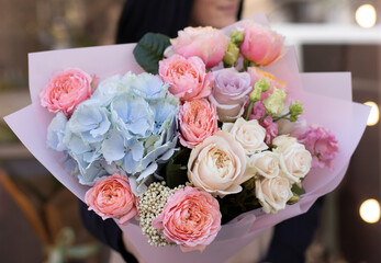 Colorful flowers assorted bouquet in bright paper. Holiday celebration concept. Bouquet of beautiful flowers in hands. Colorful flowers bouquet wrapped in paper