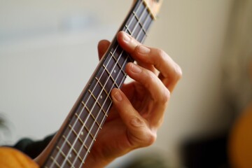 close up of a hand playing the ukulele guitar