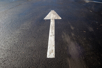 white directional arrow in parking lot