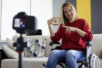 Woman in wheelchair holds bag of marijuana and shoots video blog. Video blog of marijuana products...