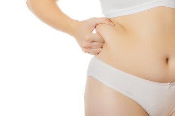 A woman in white underwear clips and shows her fat fold on the side of her stomach on a white background