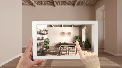 Augmented reality concept. Hand holding tablet with AR application used to simulate furniture and design products in empty interior with parquet, modern living room with dining table