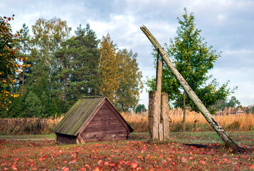 Fototapeta na wymiar Old vintage water well in the autumn field.