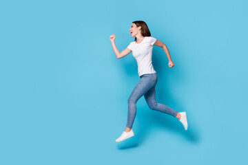 Fototapeta na wymiar Full length body size profile side view of active sportive strong endurance slim fit skinny cheerful cheery girl jumping running motion action isolated bright vivid shine vibrant blue color background