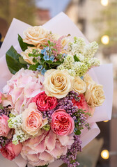 Colorful flowers assorted bouquet in bright paper. Holiday celebration concept. Bouquet of beautiful flowers in hands. Colorful flowers bouquet wrapped in paper