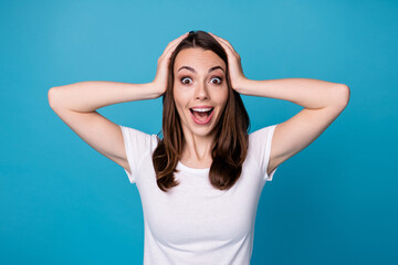 Fototapeta na wymiar Photo of attractive pretty funny lady good mood charming cute straight hairstyle arms on head shocked amazing news wear casual white t-shirt isolated blue color background