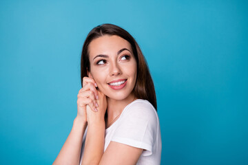Fototapeta premium Closeup profile photo of charming cute pretty lady hold arms near cheeks face beaming smile overjoyed look side up empty space wear casual white t-shirt isolated blue color background