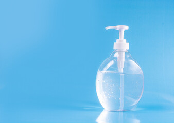 Bottle sanitizer gel alcohol desinfectant for hands in neutral background blue