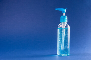 Bottle sanitizer gel alcohol desinfectant for hands in neutral background blue