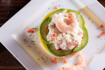 Causa with seafood prawns typical peruvian food in wood table