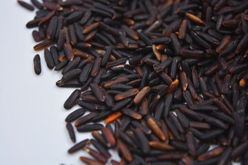 Useful black long unpolished wild rice sprinkled on a white plate. Healthy food, healthy cereals for every day is natural rice.