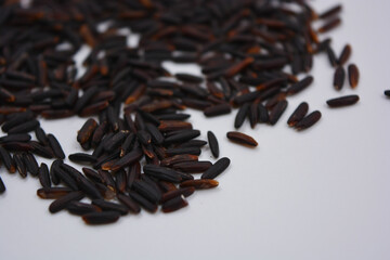Useful black long unpolished wild rice sprinkled on a white plate. Healthy food, healthy cereals for every day is natural rice.