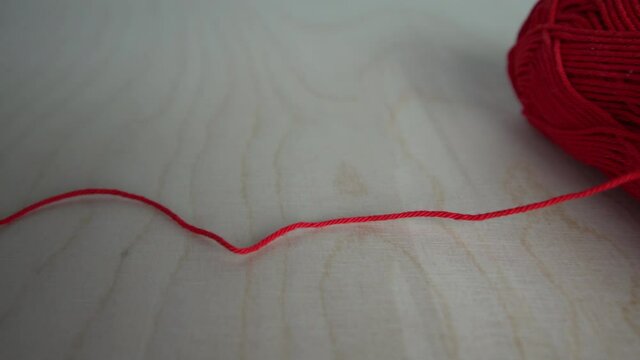 Red yarn ball on wooden table