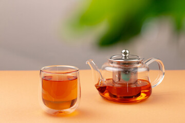 Glass teapot and cup with black tea