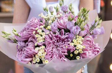 Colorful flowers assorted bouquet in bright paper. Holiday celebration concept. Bouquet of beautiful flowers in hands. Colorful flowers bouquet wrapped in paper