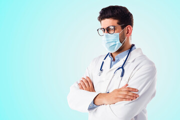 Male doctor wearing face mask while standing at isolated background