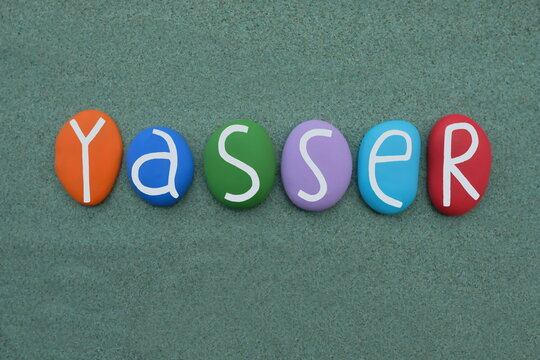 Yasser, Arabic male name meaning wide thinking, celebrated with handmade multicolored stone letters over green sand