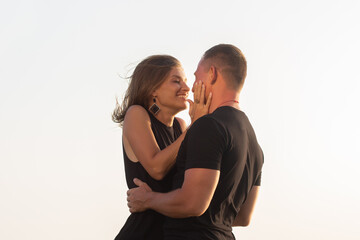 Happy couple of young men and women running, laughing and holding hands on a deserted tropical beach at sunset