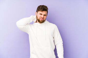 Young caucasian man isolated on purple background suffering neck pain due to sedentary lifestyle.