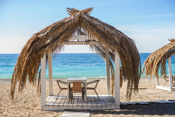 The bungalows are made from palm branches on the blue of the sea