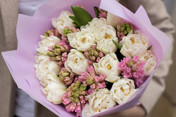 Fresh beautiful flower. Woman holding a big delicate flower bouquet wrapped in paper.