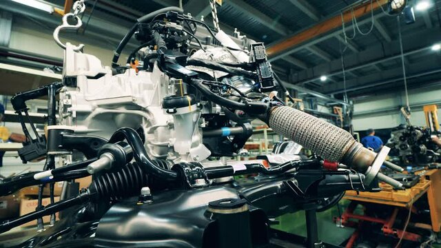 Automobile factory, car production, auto production line. Mechanical assembly of car elements held in a factory unit