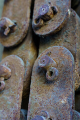 Vertical photo of old rusty iron pieces linked together