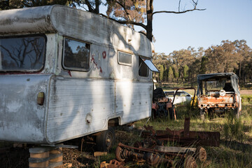 Old disused abandoned caravan van farm yard rural shadow bush trailer park rusty sunset