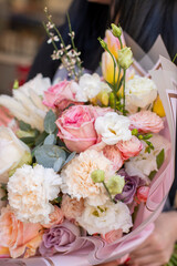 Fresh beautiful flower. Woman holding a big delicate flower bouquet wrapped in paper.