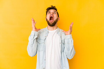 Young caucasian man isolated on yellow background screaming to the sky, looking up, frustrated.