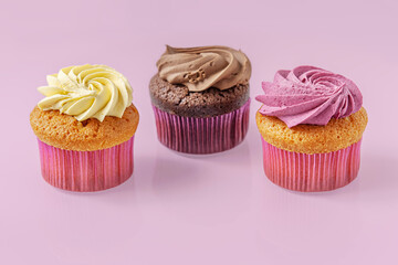 assorted cupcakes on a light purple glass surface close up