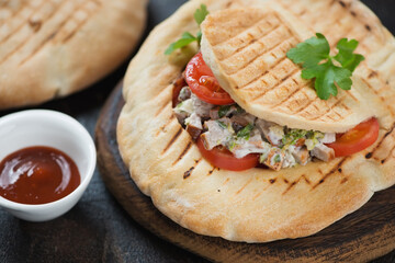 Close-up of doner kebab with meat and vegetables served in pita bread, selective focus, studio shot