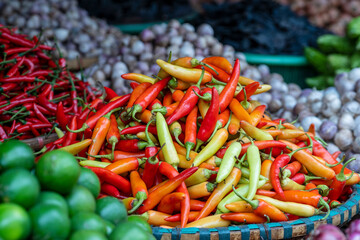Orange, yellow and red sweet peppers for sale at street food market in the old town of Hanoi, Vietnam.
