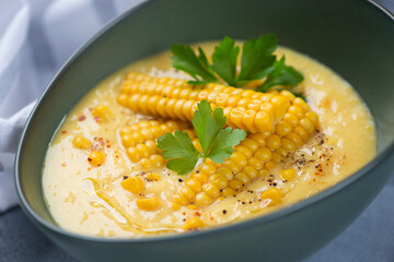 Gazpacho cold soup made of sweet corn and served in a green bowl, selective focus, closeup