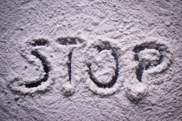 Word Stop written in white flour powder. Concepts of drug abuse as people turn to narcotics abuse during the hard times of covid global pandemic. Raising awarness to the problem