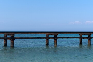 Fototapeta na wymiar old rusty base of sea marina against the backdrop of endless sea horizon