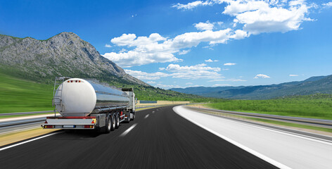 big fuel gas tanker truck on highway against the backdrop of a mountain landscape.