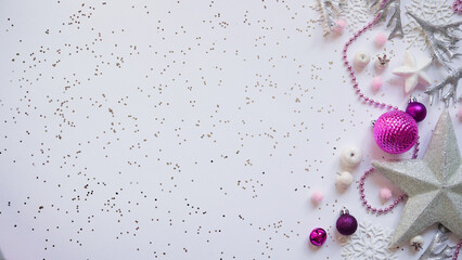 Christmas and New Year white stars,snowflakes and purple Christmas balls and decorations among sparkles on white background,top view,flat lay,copy space,Christmas festive background. Festive postcard