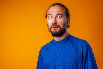 Amazed and confused bearded man looks with astonishment